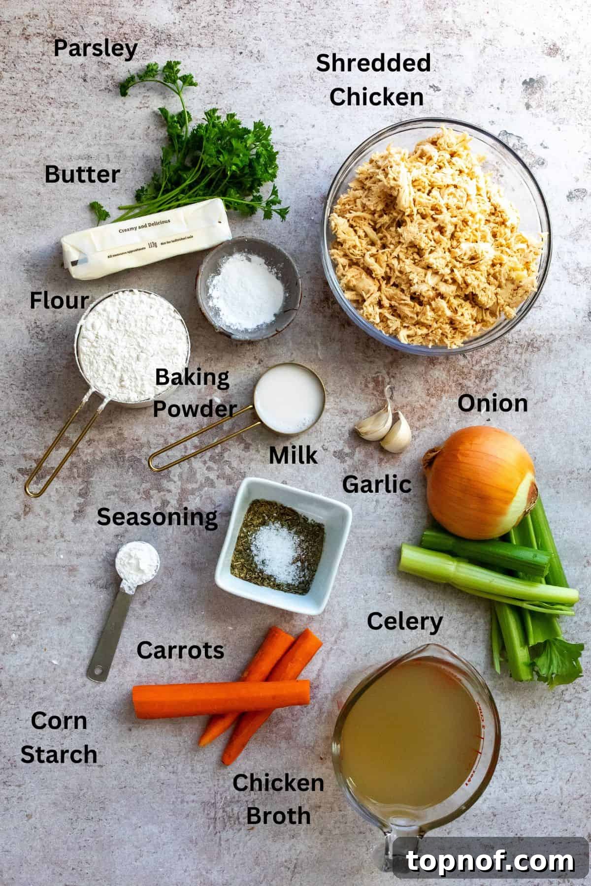 All the fresh ingredients for creamy chicken and dumpling soup meticulously arranged in small bowls and measuring cups on a kitchen counter.