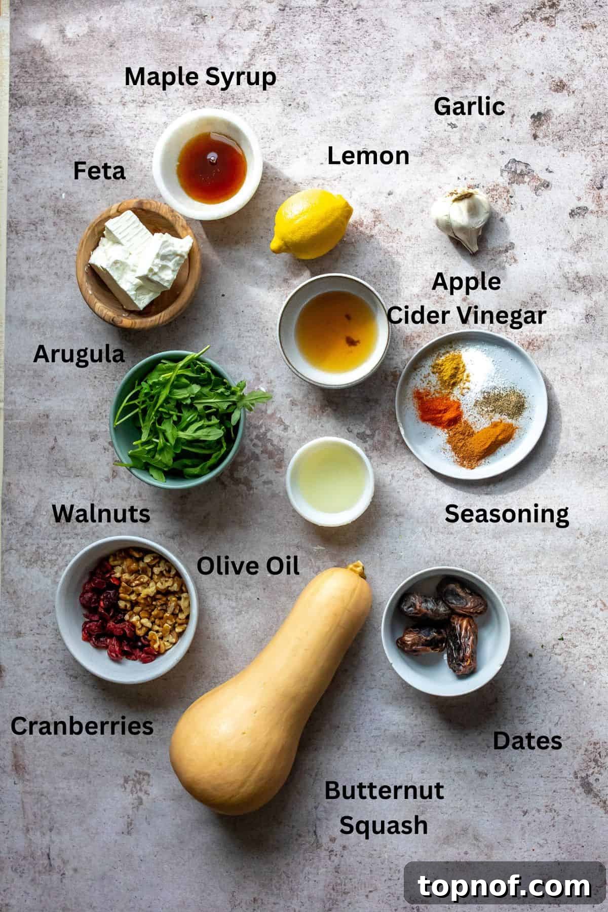 Fresh ingredients laid out for Butternut Squash Feta Salad, including butternut squash, arugula, dates, and spices.