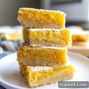 Lemon Cookie Bars stacked on each other on a plate.