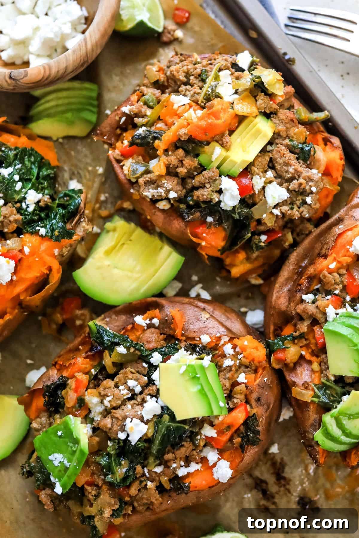 Savory Beef Sweet Potato Boats 6 Up close photo of stuffed sweet potatoes with Mexican inspired toppings and avocado, garnished and ready to eat.