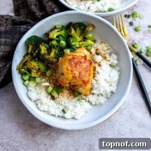 White ceramic bowls with rice and cooked chicken and green onions for garnish. Gold forks on the side.