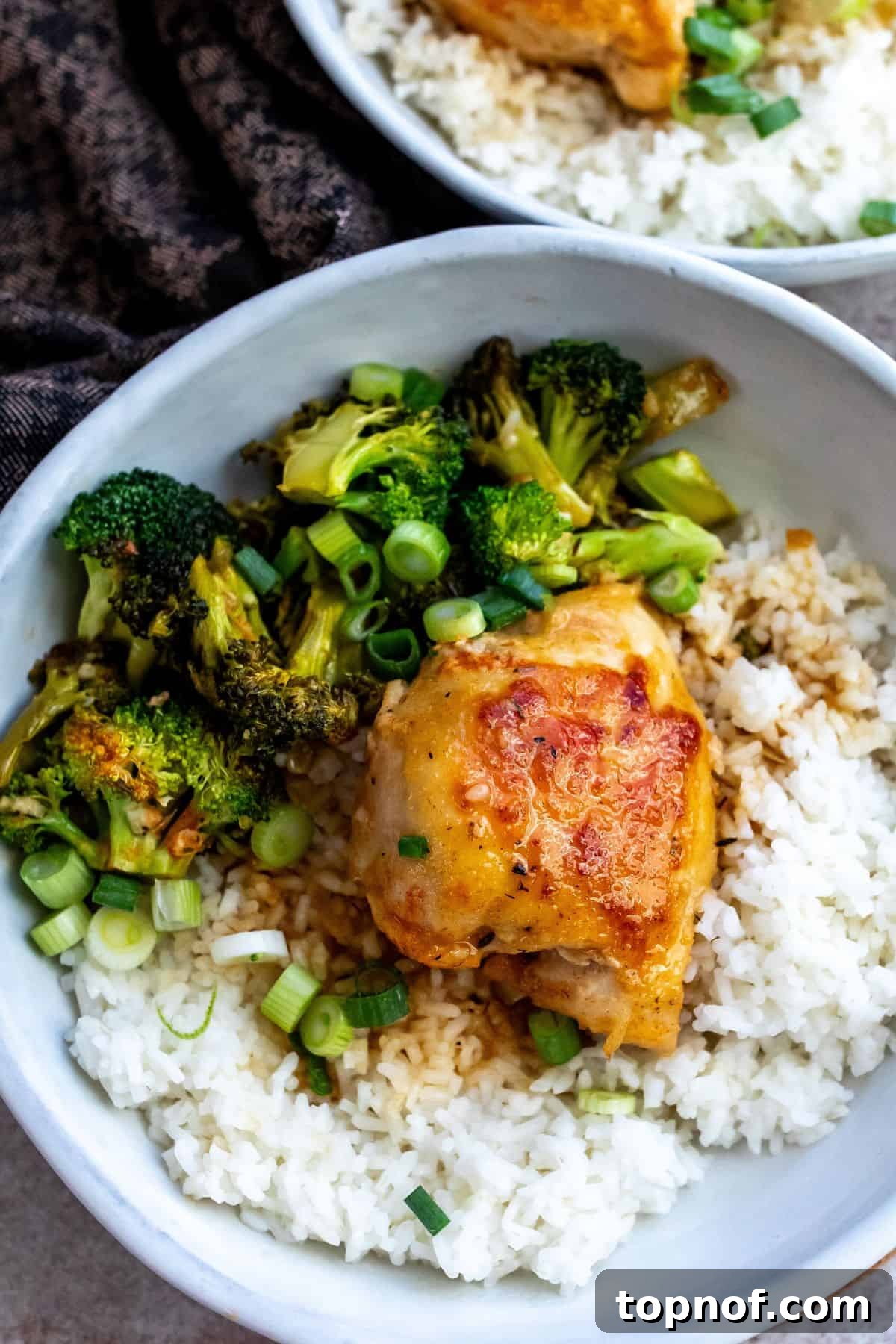 Maple Glazed Chicken 6 Ceramic bowl with chicken and rice and lots of broccoli inside.