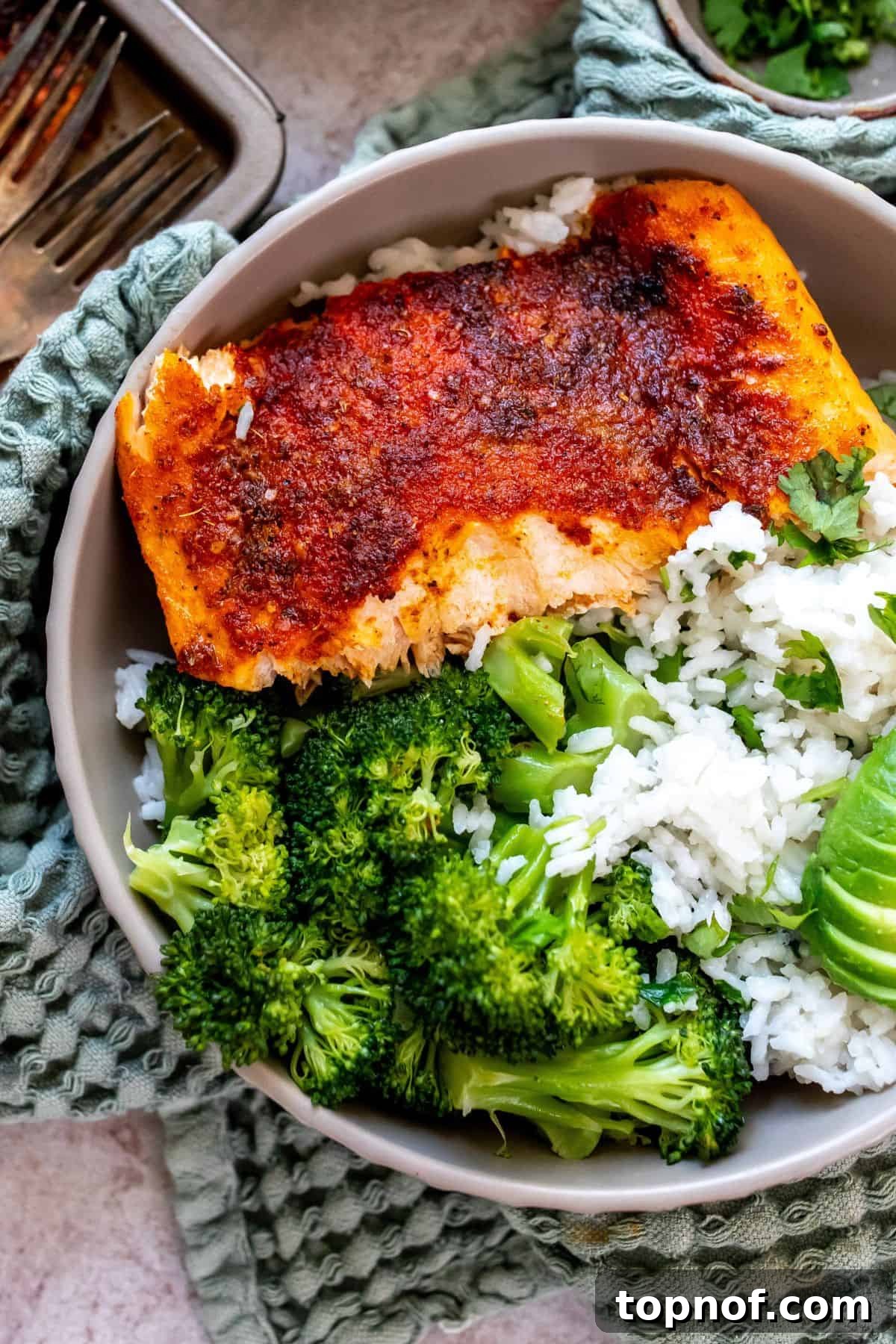 Zesty Baked Blackened Salmon 5 Grey bowl on a green towel with coconut rice and salmon in the bowl.