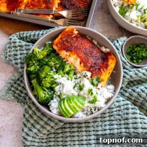 Grey bowl on a green towel with coconut rice and salmon in the bowl.