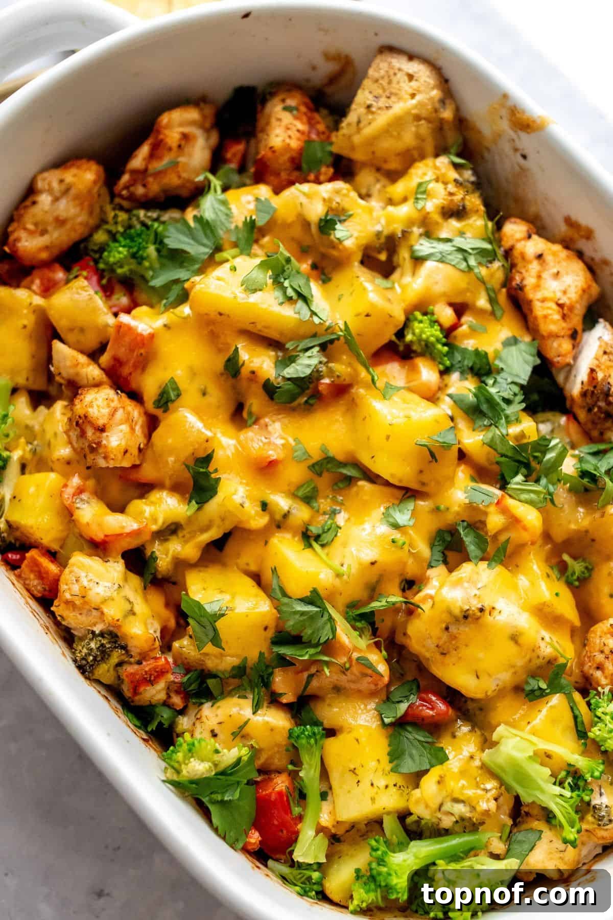 Hearty Chicken Broccoli Potato Bake 2 White baking dish with chicken broccoli potato casserole in it.
