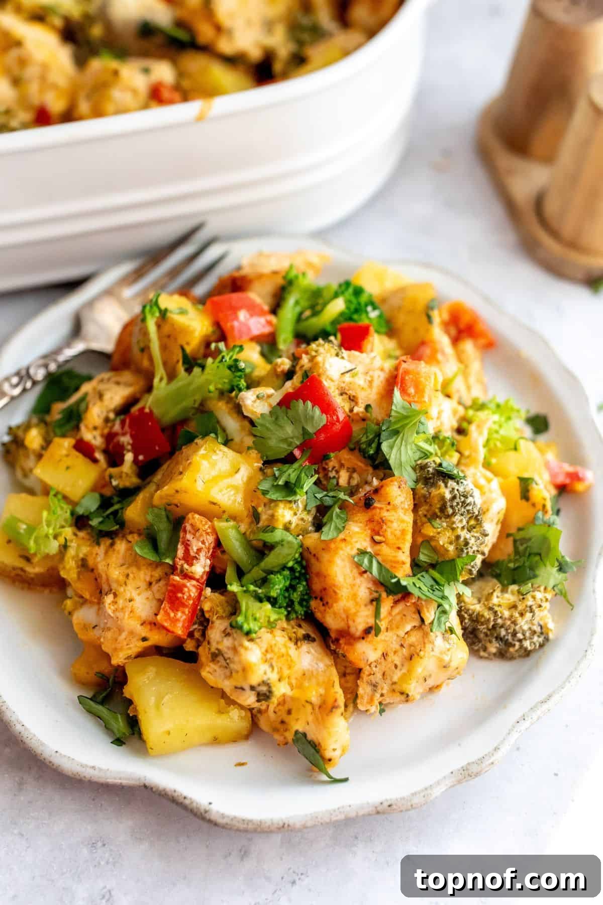 Hearty Chicken Broccoli Potato Bake 5 White baking dish with chicken broccoli potato casserole in it.