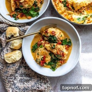 Creamy Tuscan Chicken Skillet 7 White bowl with chicken and sauce in it, and a gold fork. Bread on the side.