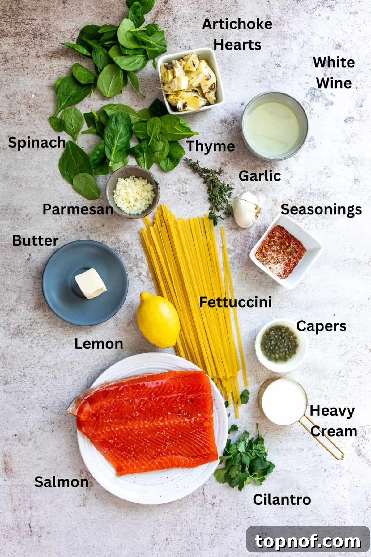 Lemon Herb Salmon Pasta Bake 3 Assortment of fresh ingredients for salmon pasta, including salmon fillet, spinach, lemon, capers, and seasonings.
