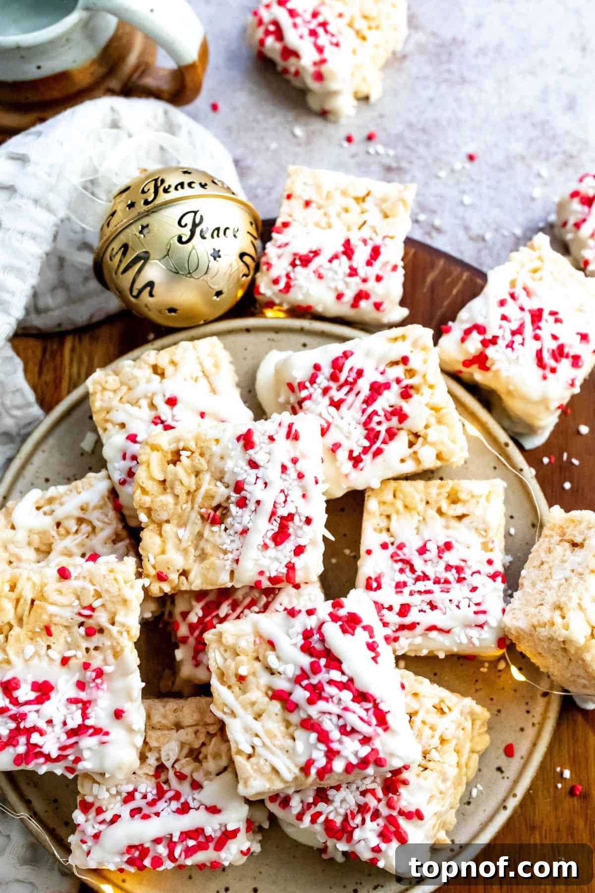 A plate brimming with vibrantly decorated Christmas Rice Krispie Treats, adorned with edible holiday sprinkles and surrounded by soft, twinkling lights, creating a warm and inviting holiday atmosphere.
