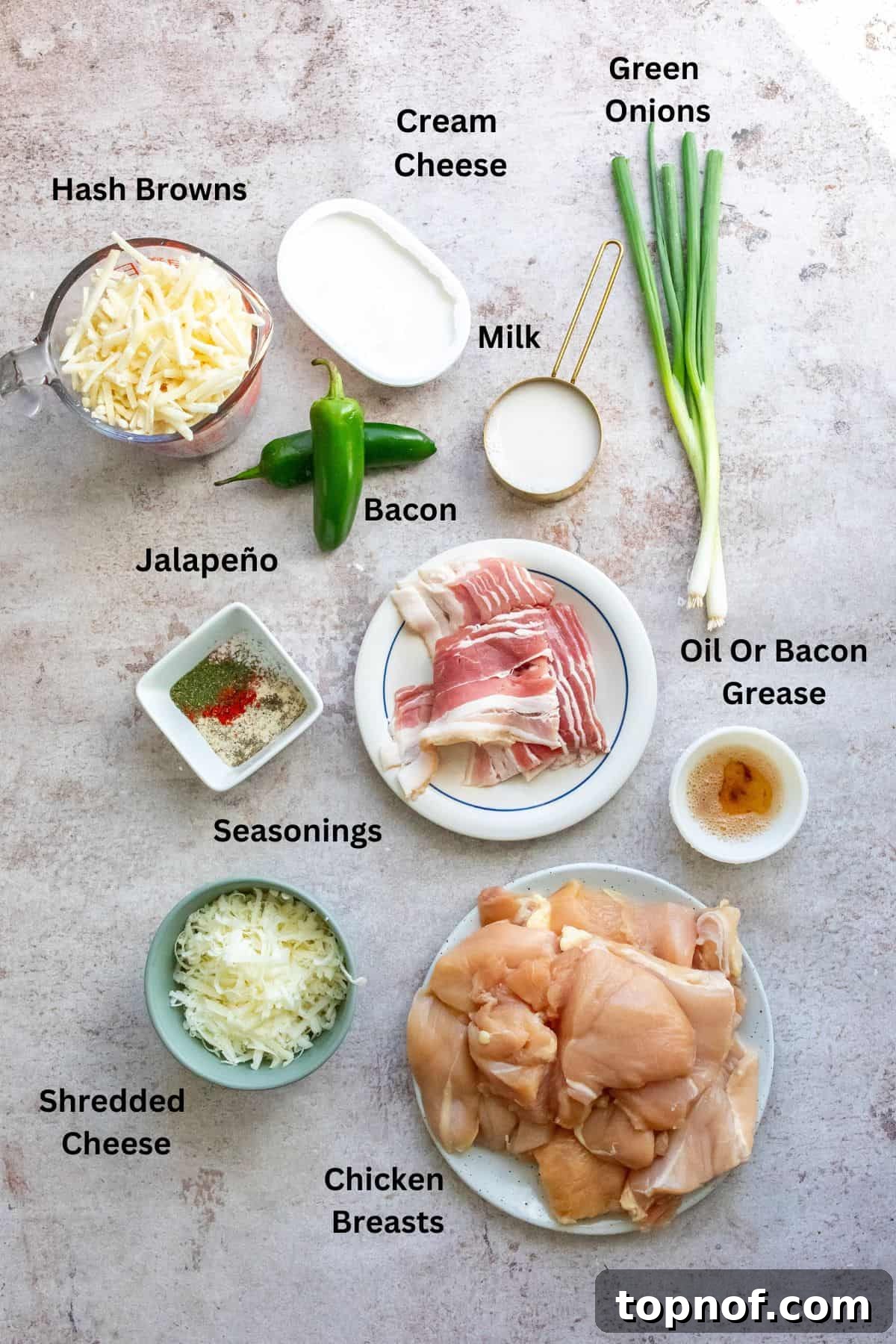 Hearty Chicken Hash Brown Bake 3 A collection of fresh ingredients, neatly arranged in small bowls and containers on a pristine white countertop, ready for casserole preparation.