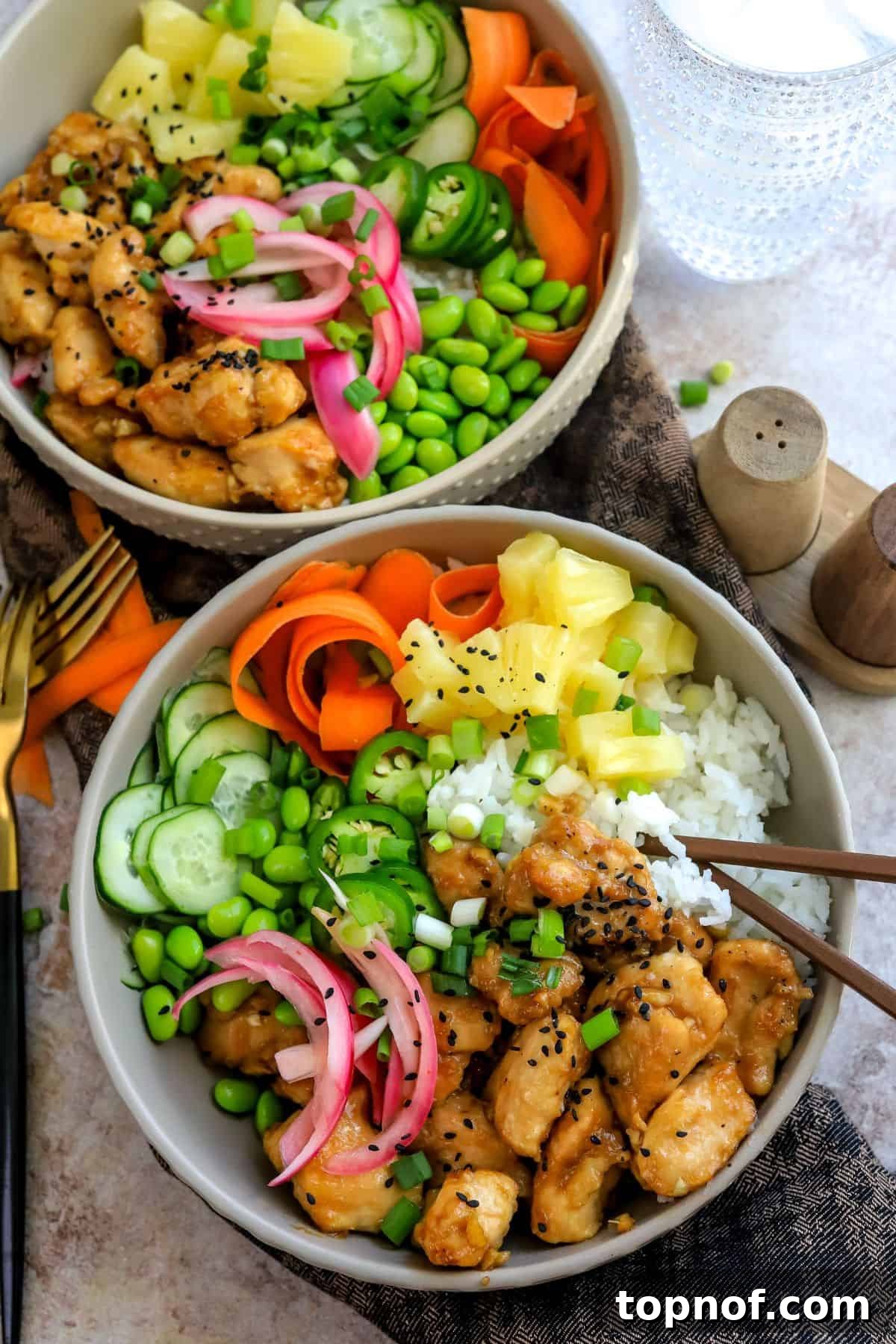 Fresh Chicken Poke Bowl 2 A beautifully arranged Chicken Poke Bowl in a grey ceramic bowl, garnished with fresh toppings and chopsticks on the side.