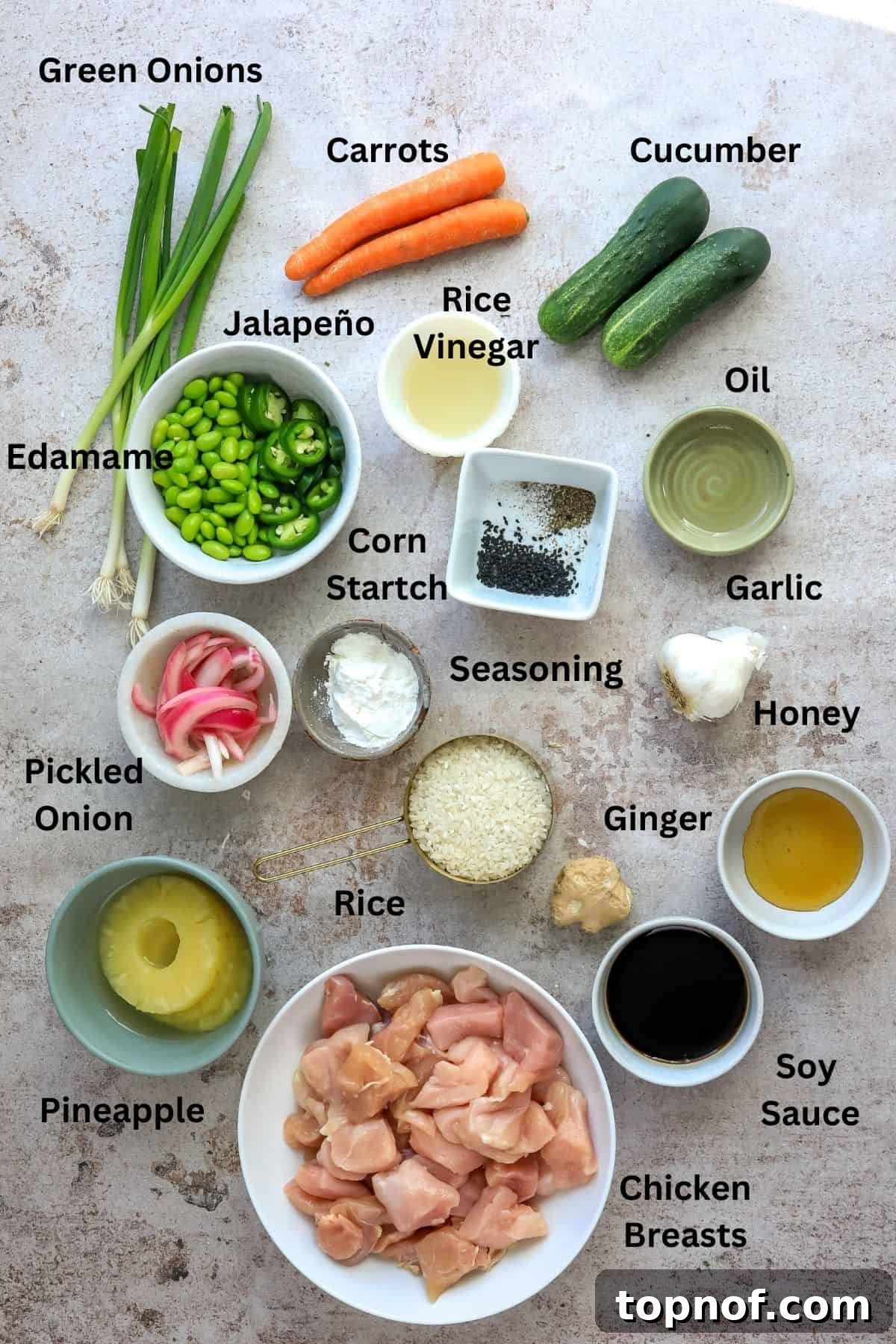 Fresh Chicken Poke Bowl 3 A collection of fresh ingredients laid out on a kitchen counter in small bowls and plates, ready for making chicken poke bowls.