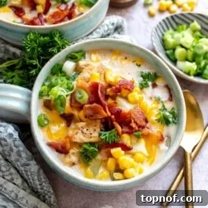 Golden Chicken Corn Chowder 7 Soup mugs with a handle on a counter with corn chowder and bacon on top. Gold spoon to the side.