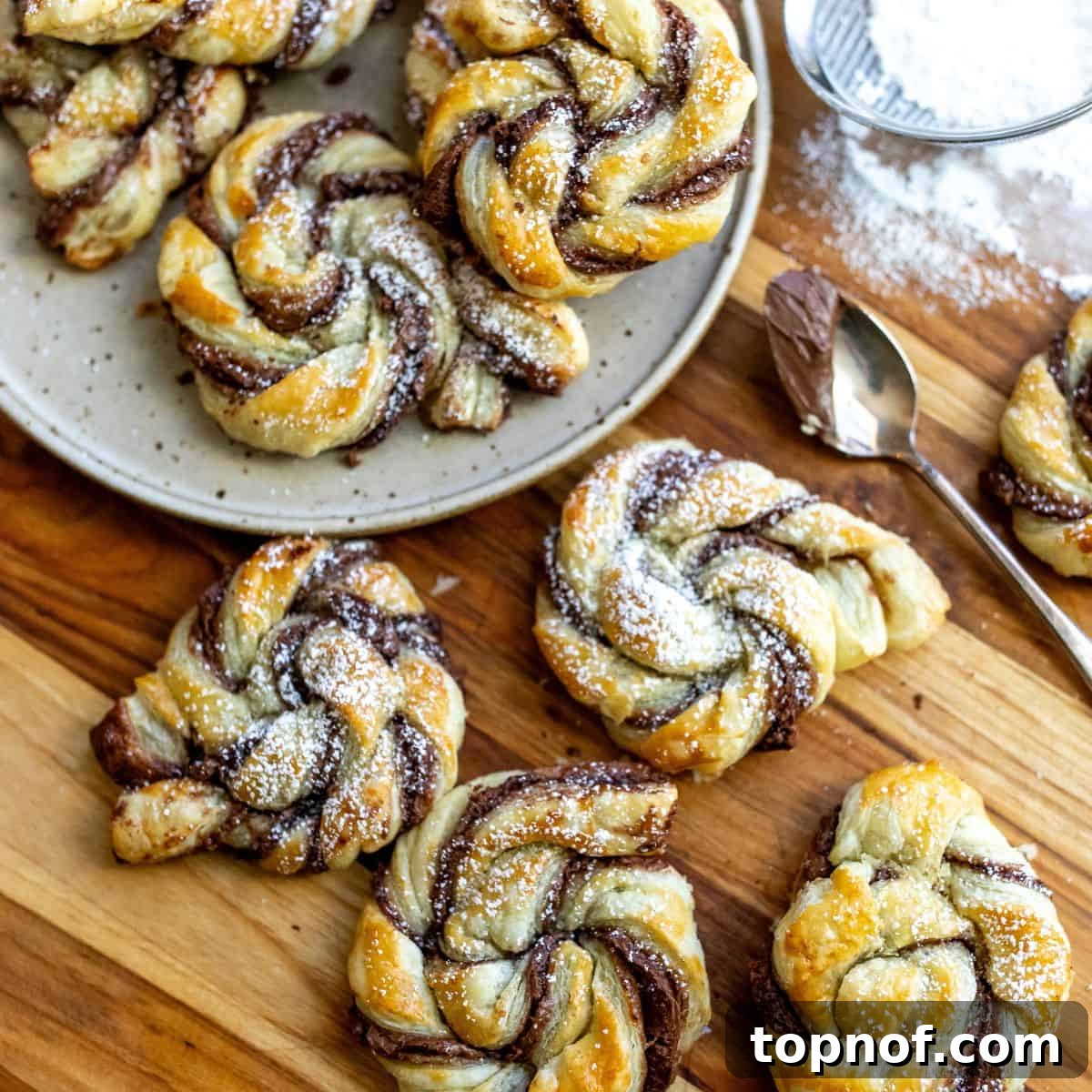 Golden-brown pastries with rich Nutella swirled inside, presented on a plate, highlighting their flaky and decadent appeal.