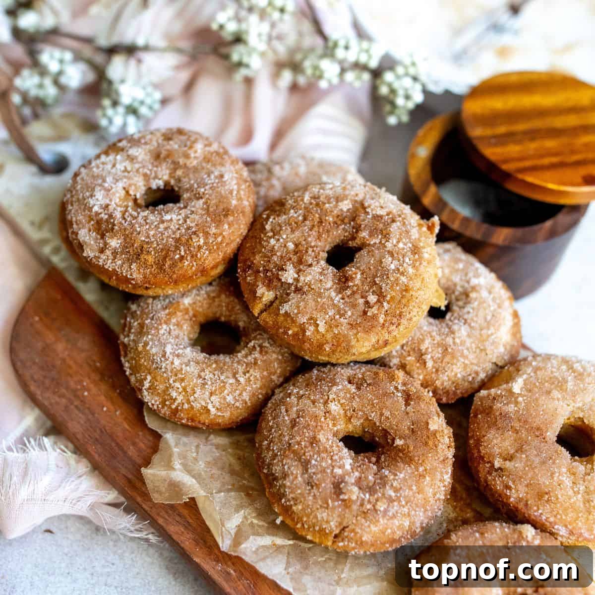 Golden-brown Baked Apple Cider Donuts, crispy on the outside and doughy inside, highlighting their delicious apple spice and cider flavors.