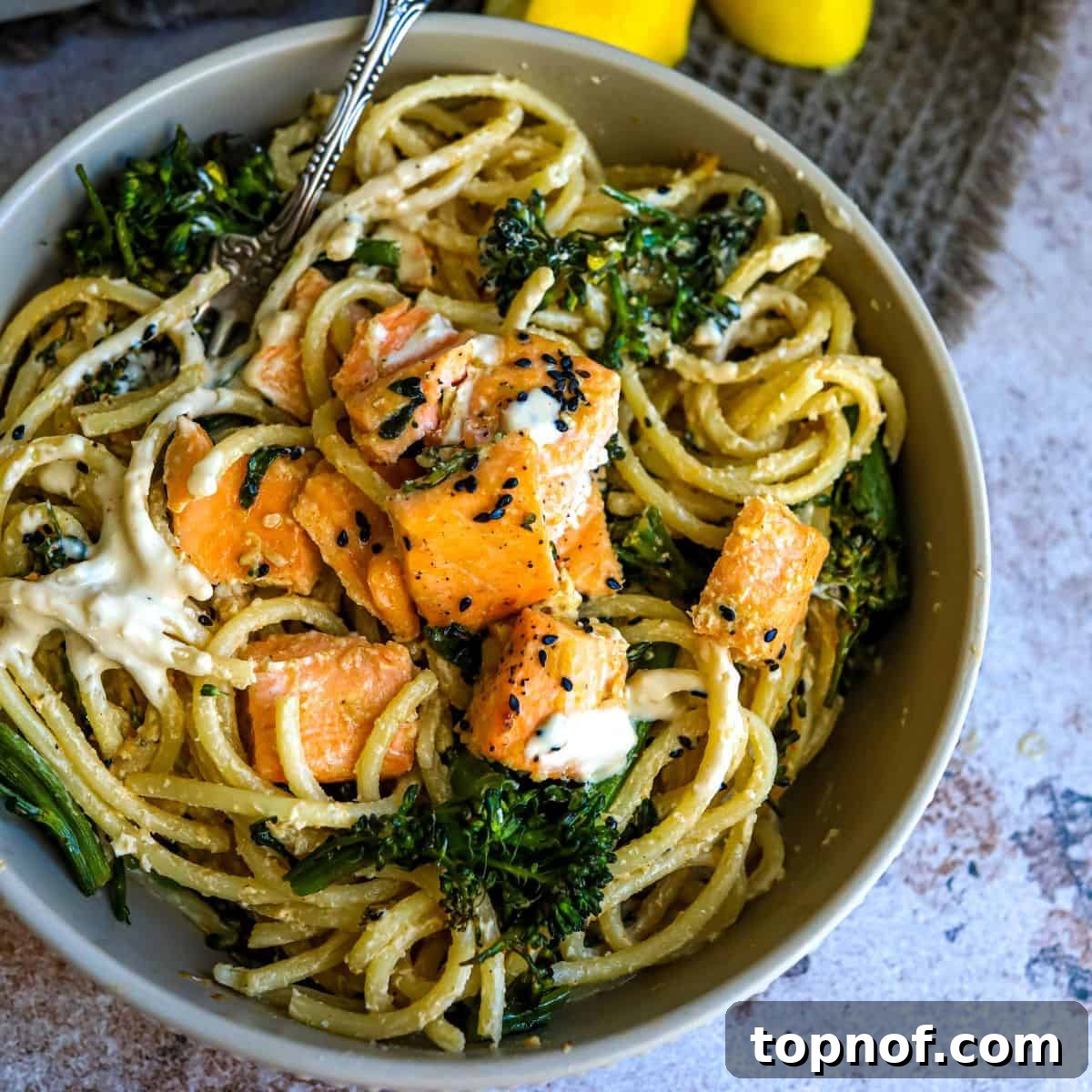 Grey bowl showcasing tender noodles and perfectly cooked salmon, ready to enjoy.