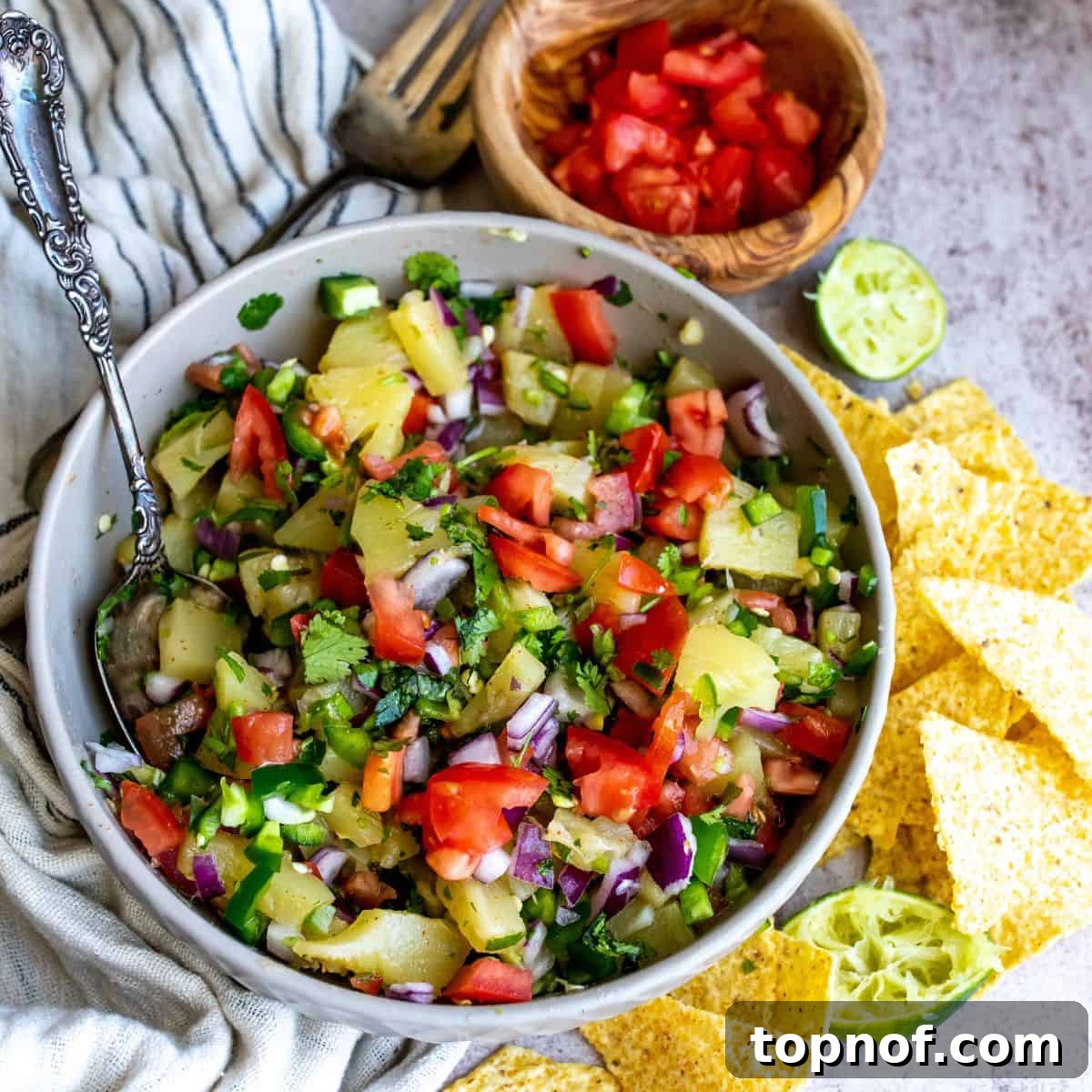 Grey bowl filled with a colorful Pineapple Pico De Gallo, featuring pineapple, tomatoes, and jalapeños.