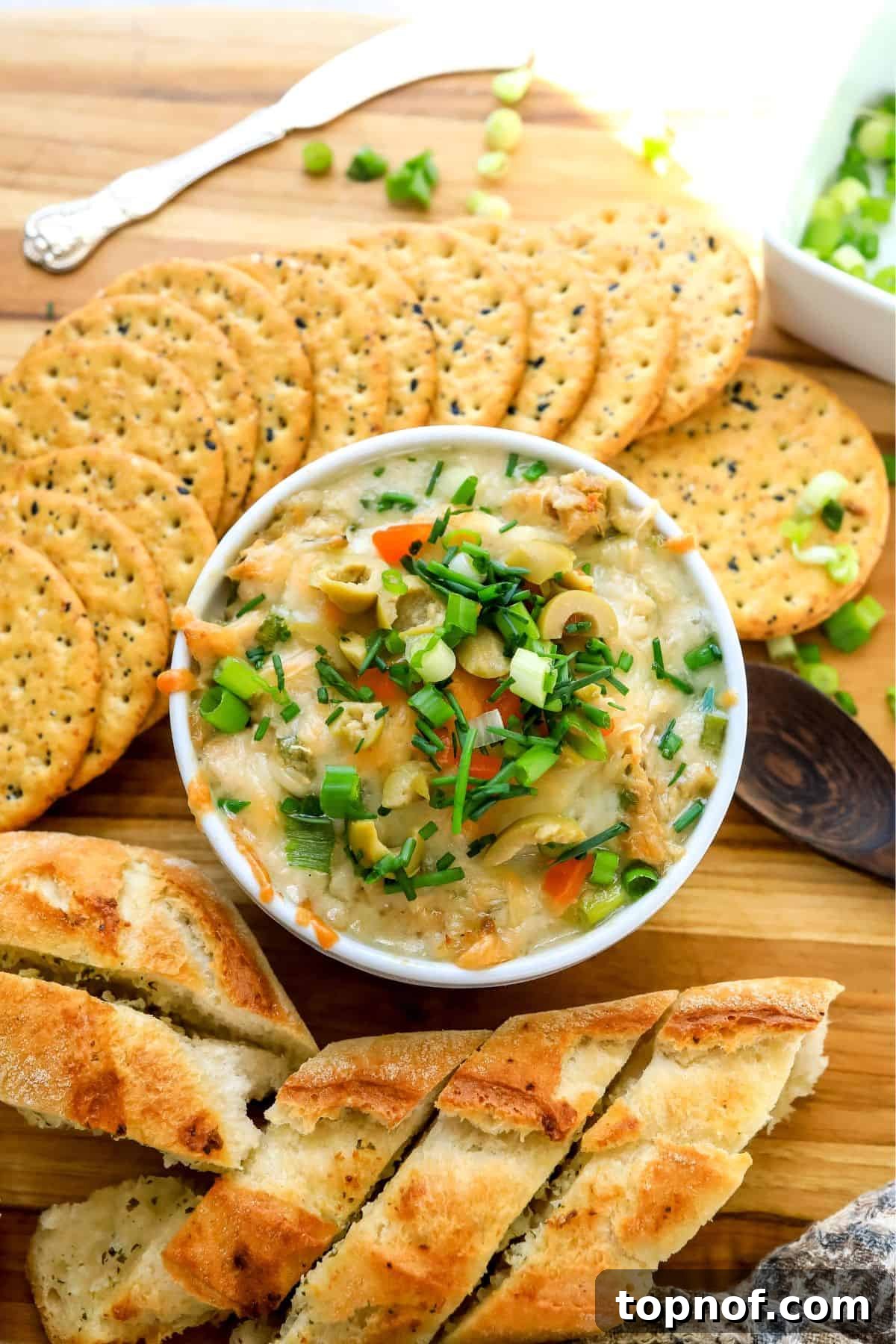 White ramekin filled with savory Tuna Dip, accompanied by crispy gluten-free crackers on the side.