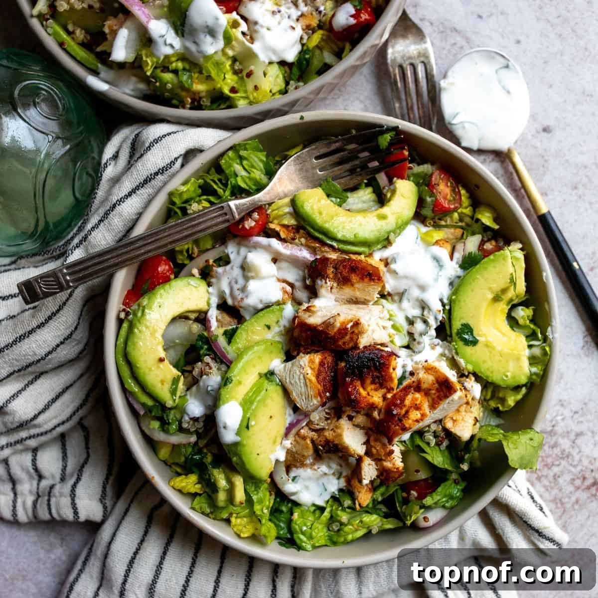 Grey bowl brimming with a fresh salad and perfectly sliced avocado.