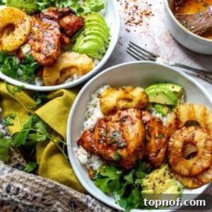 White ceramic bowls with juicy Hawaiian BBQ Chicken over rice and a fork to the side.