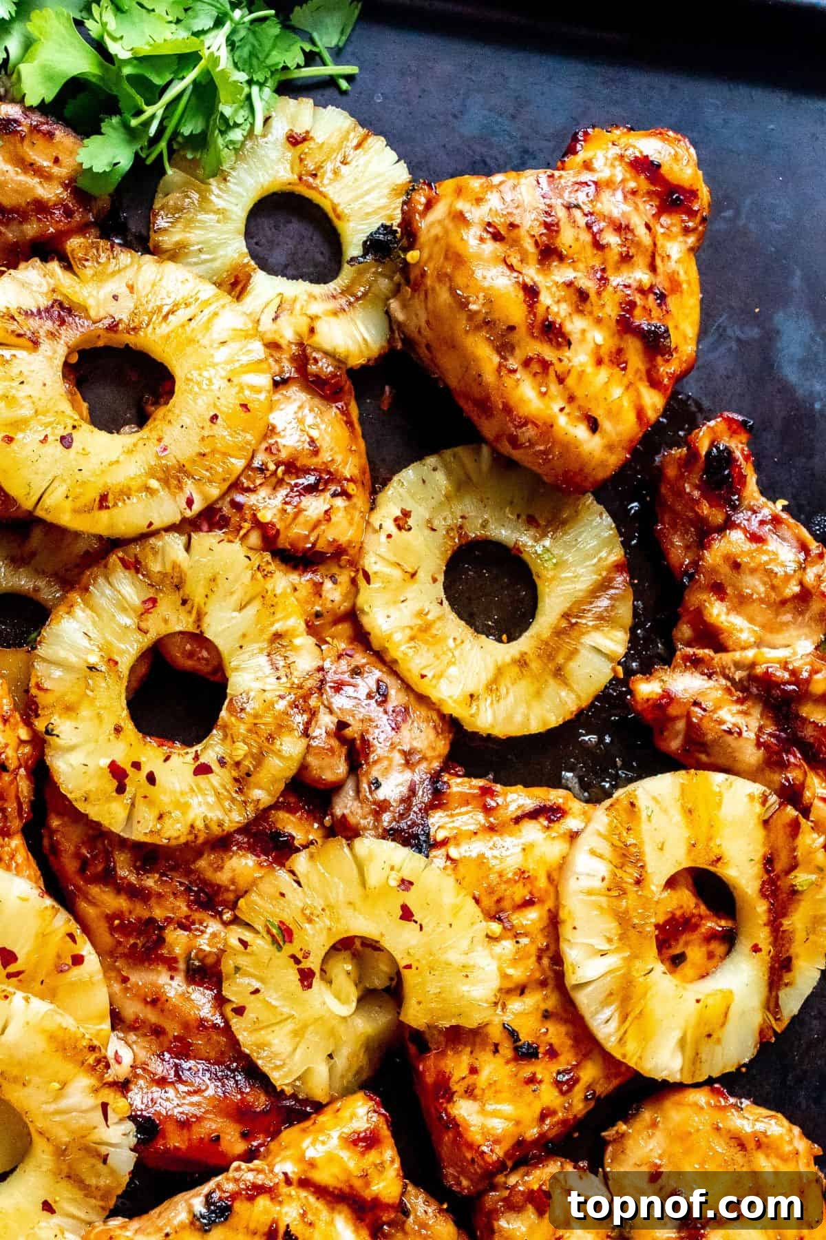 Aloha BBQ Chicken 5 Close-up of grilled Hawaiian BBQ Chicken Thighs with caramelized pineapple rings, showing the glossy glaze and tender texture.