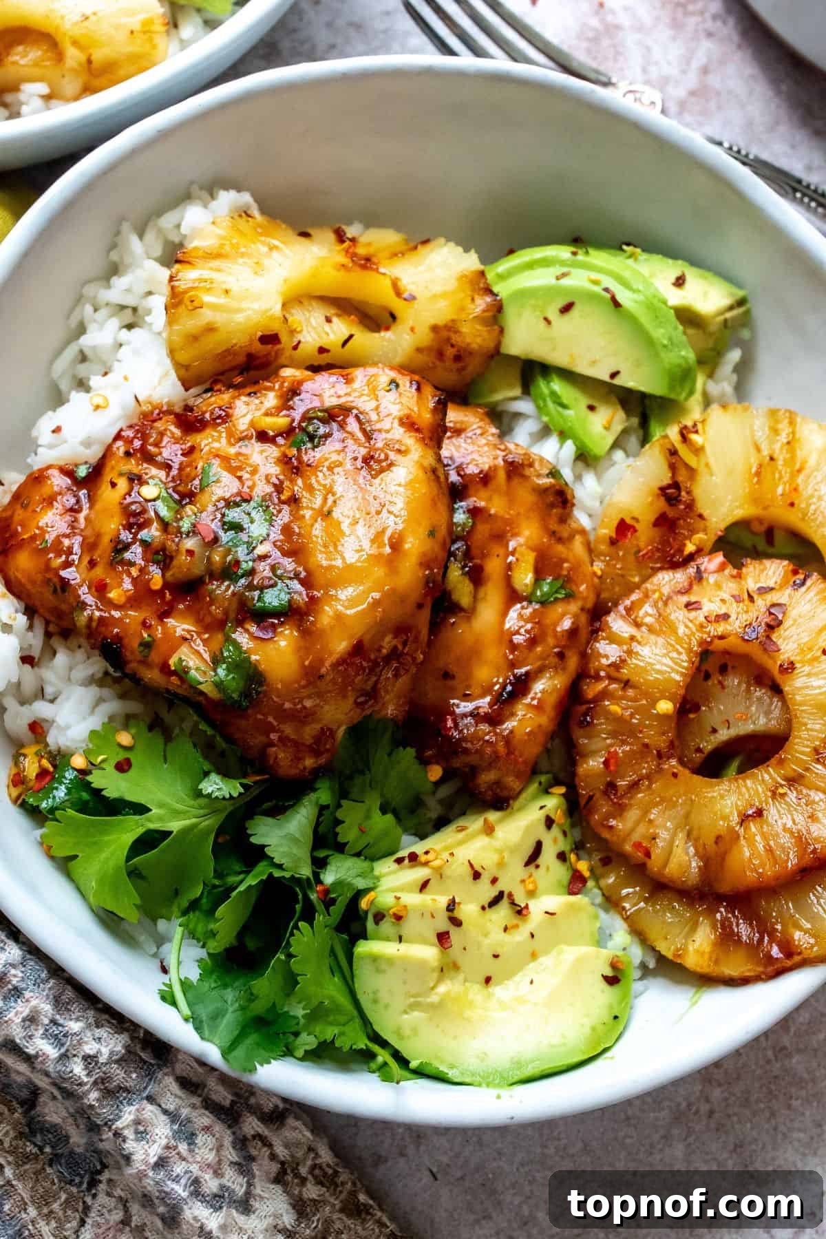 Aloha BBQ Chicken 6 A vibrant and colorful spread of Hawaiian BBQ chicken served with various fresh side dishes like rice and avocado slices.