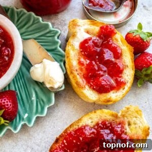 An overhead image of strawberry jam spread on two pieces of toast.