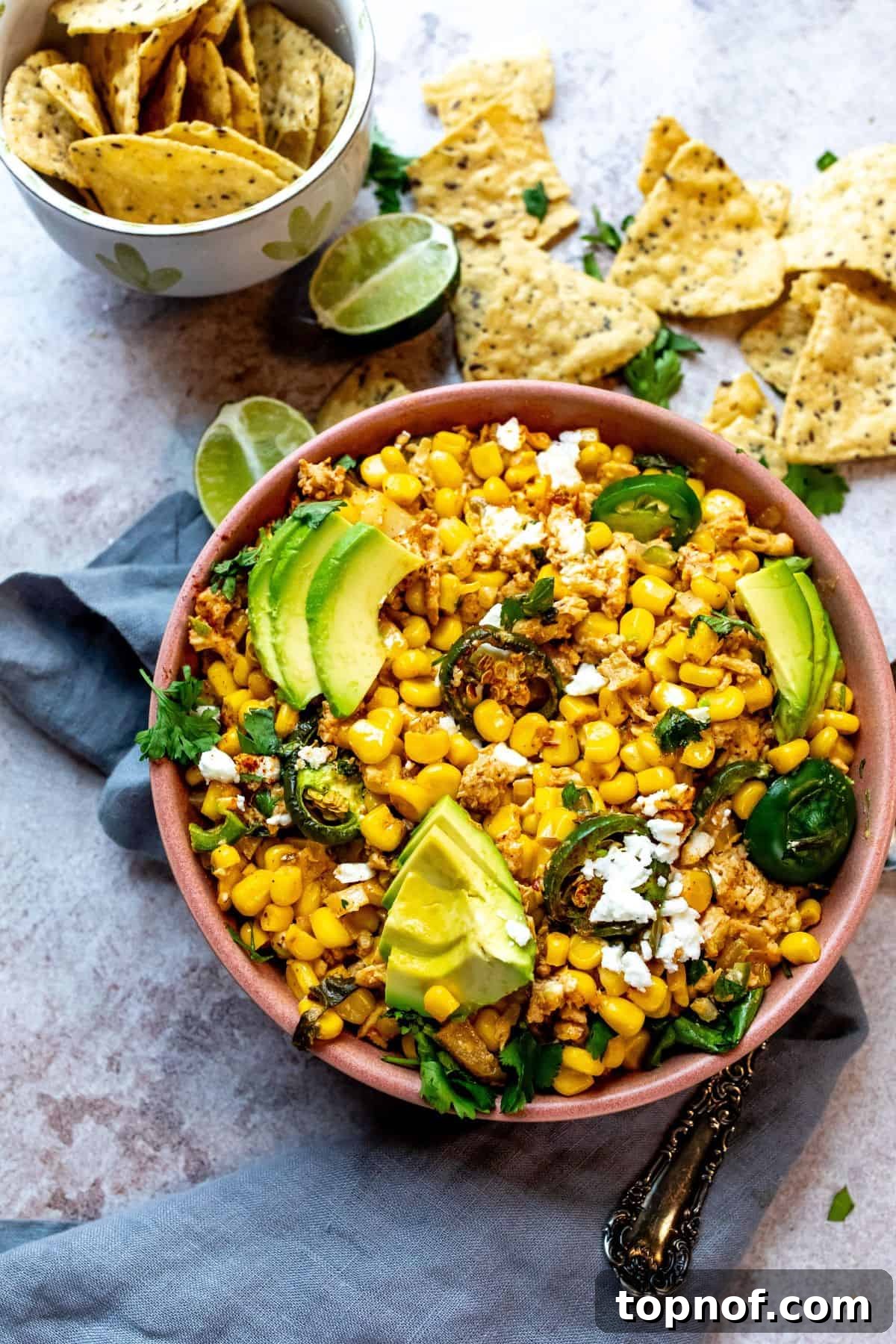 Creamy Elote Bake 2 A vibrant and creamy Mexican street corn casserole, richly garnished with fresh cilantro and crumbled cotija cheese, presented in a rustic ceramic serving bowl, ready to be enjoyed.