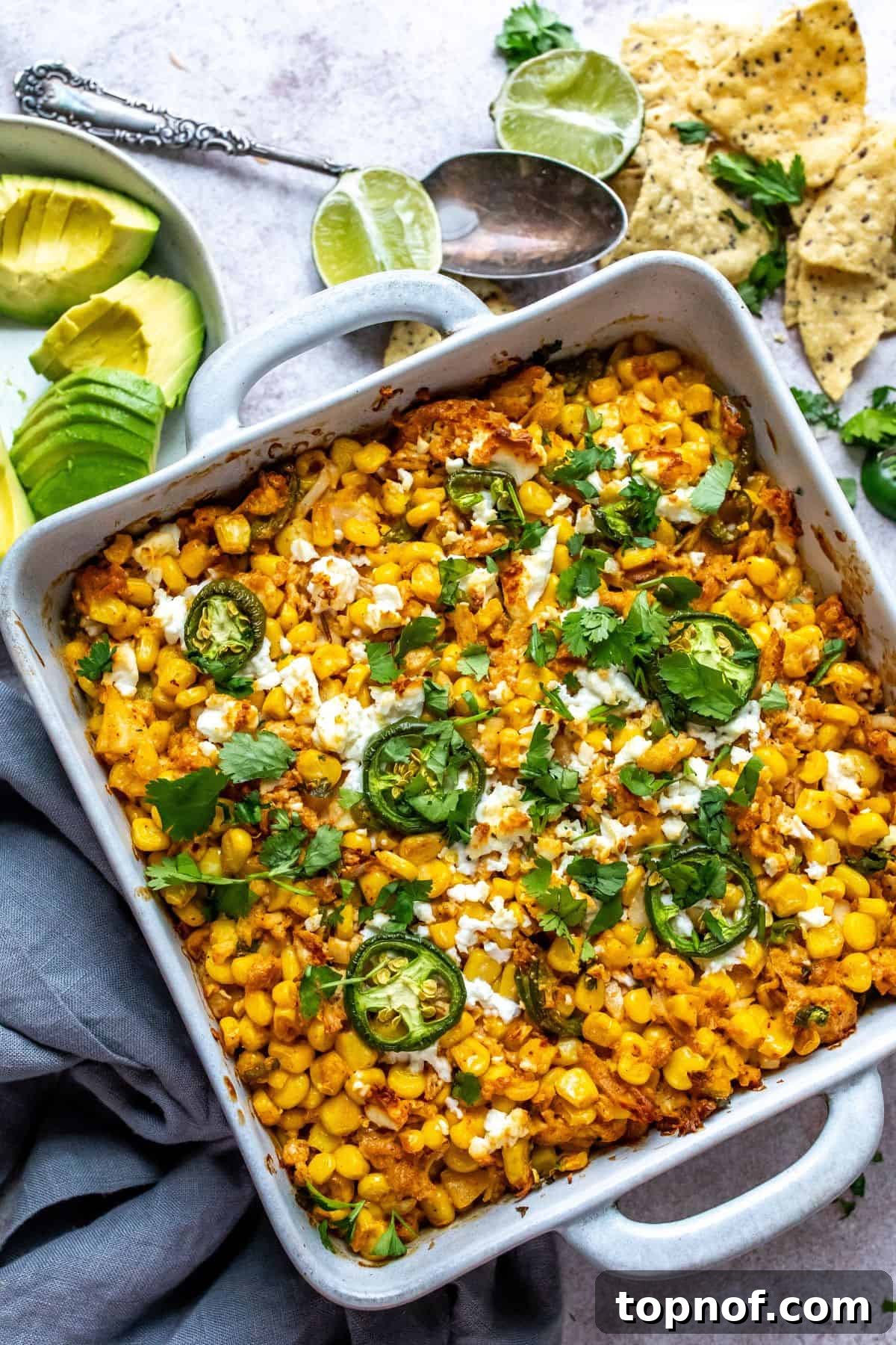 Creamy Elote Bake 6 The perfectly finished Mexican street corn casserole, freshly baked to a golden-brown, bubbly perfection in a white rectangular baking dish, with a slight char on the cheese and a fresh garnish of green cilantro, ready to be served warm.