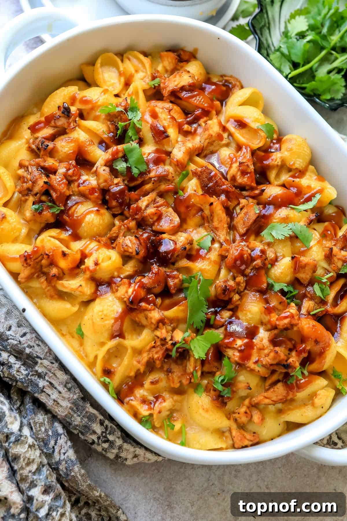 SMOKED BBQ CHICKEN MACARONI AND CHEESE 2 Creamy noodles with melted cheese and succulent BBQ chicken pieces baked to golden perfection in a white casserole dish.