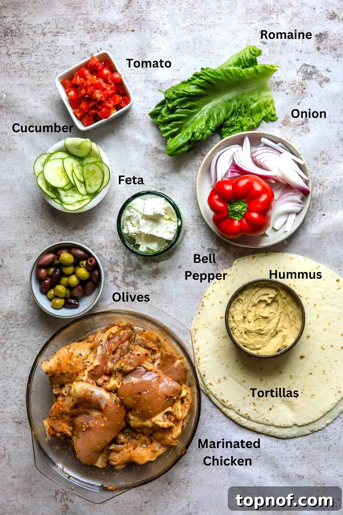 Vibrant Mediterranean Wraps 3 Assortment of fresh ingredients in various bowls and on plates, neatly arranged on a kitchen counter, ready for meal preparation.