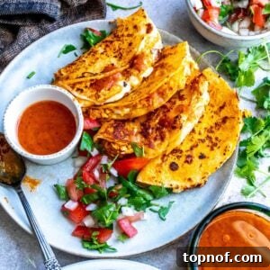 Two Chicken Birria Tacos with dipping sauce and pico de gallo on the side.