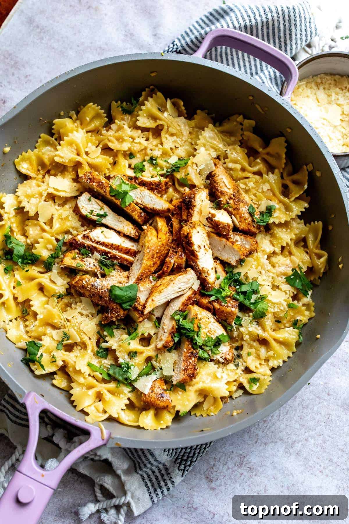 An overhead shot of a skillet filled with creamy garlic parmesan chicken pasta, garnished with fresh herbs, ready to be served.