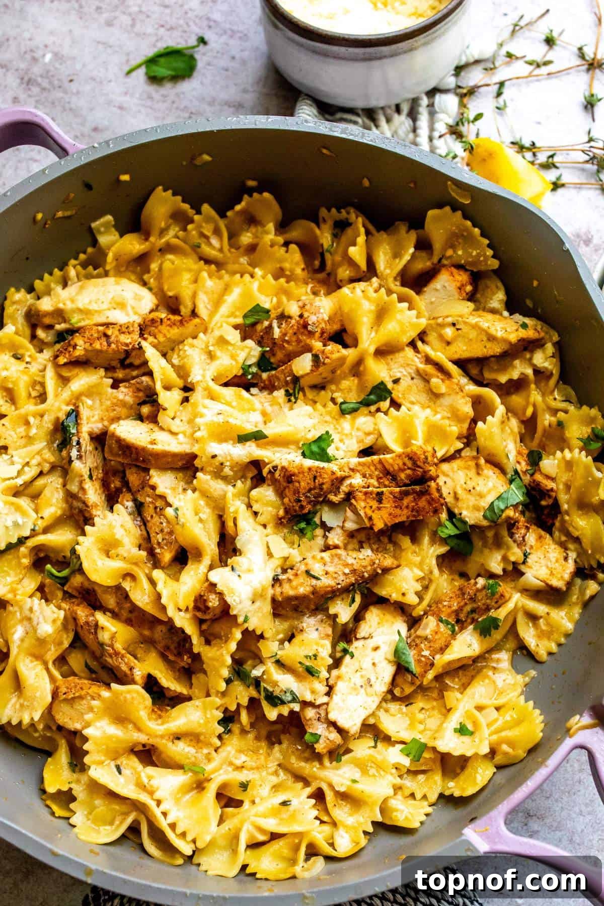 An overhead view of the finished garlic parmesan chicken pasta in a large skillet, ready for serving.