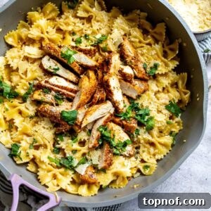 An overhead image of garlic parmesan chicken pasta in a skillet, garnished and ready to serve.