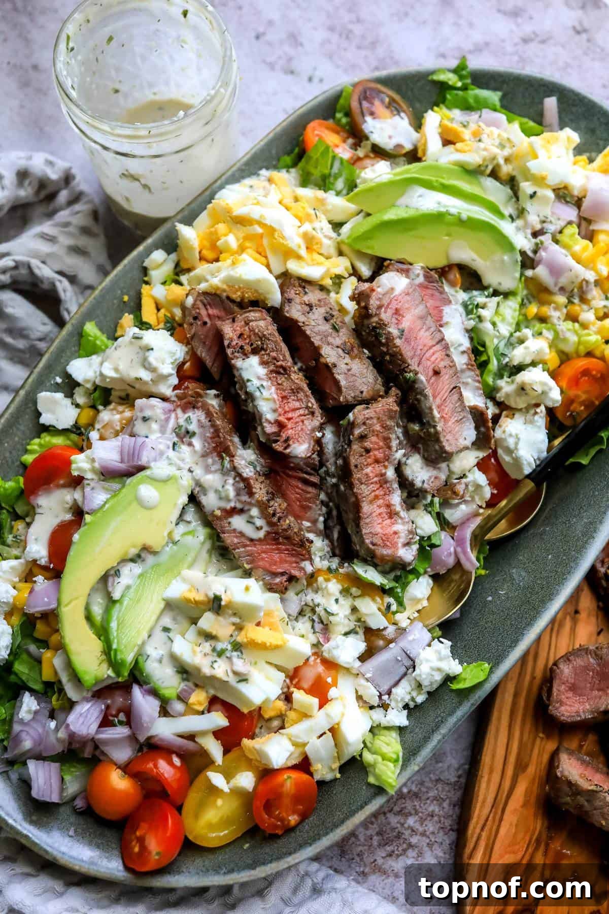 Hearty Steak Salad 2 A vibrant grilled steak salad with hard-boiled eggs, fresh greens, and a creamy dressing, ready to be served.