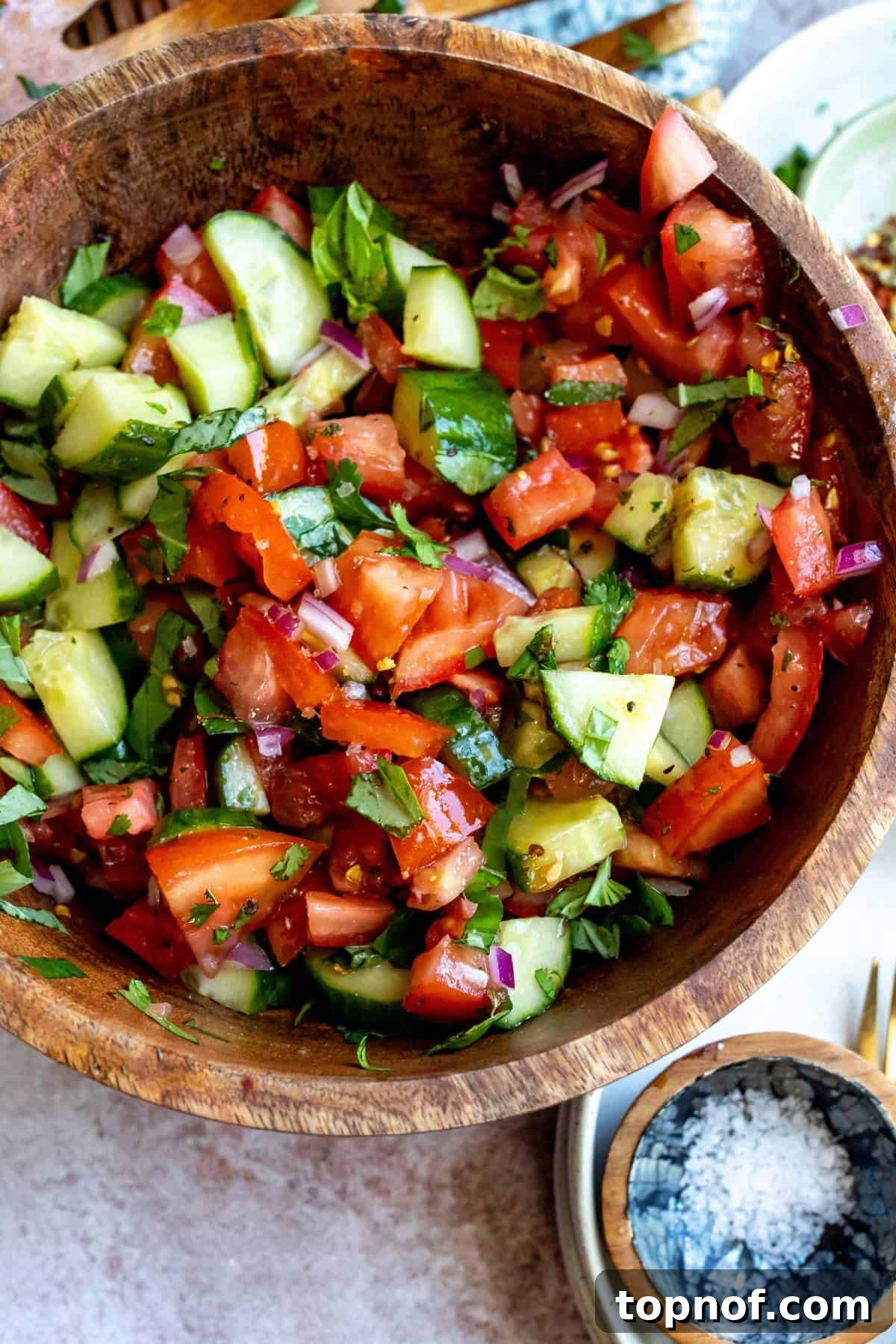 Garden Fresh Tomato Cucumber Salad 5 Another perspective of the wooden bowl with fresh Cucumber Tomato Salad, showcasing its vibrant colors and inviting texture.