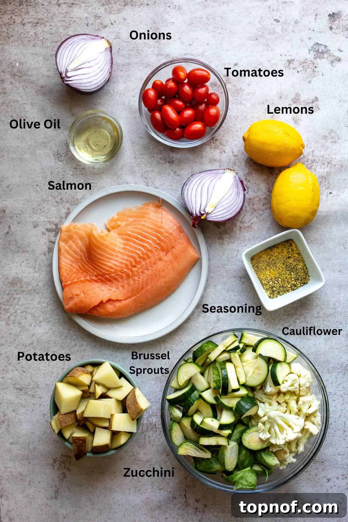 Zesty Sheet Pan Salmon and Roasted Garden Vegetables 3 A flat lay image displaying all the fresh ingredients required for making lemon pepper salmon and roasted vegetables, including salmon fillets, lemons, fresh vegetables, and spices.