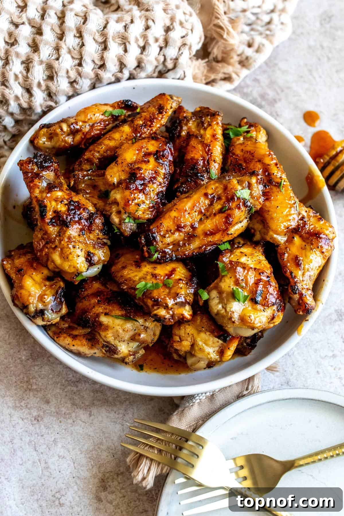 Sticky Sweet Heat Wings 2 White ceramic bowl with sauce hot honey wings in it.