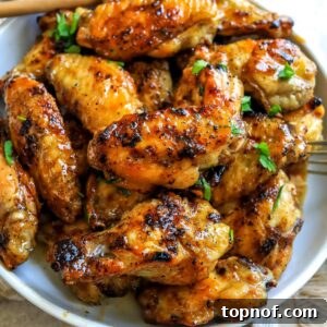 Sticky Sweet Heat Wings 6 White ceramic bowl with sauce hot honey wings in it.