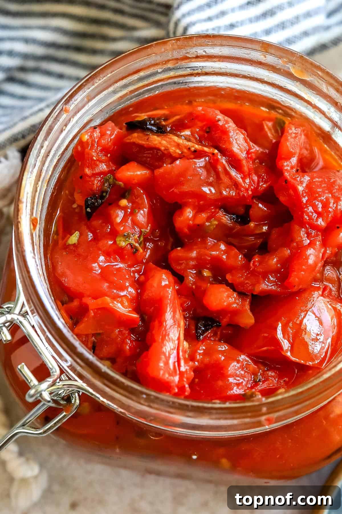 Close-up of freshly roasted tomatoes, showing the perfect balance of softened flesh and delightfully charred edges, glistening with olive oil and herbs.