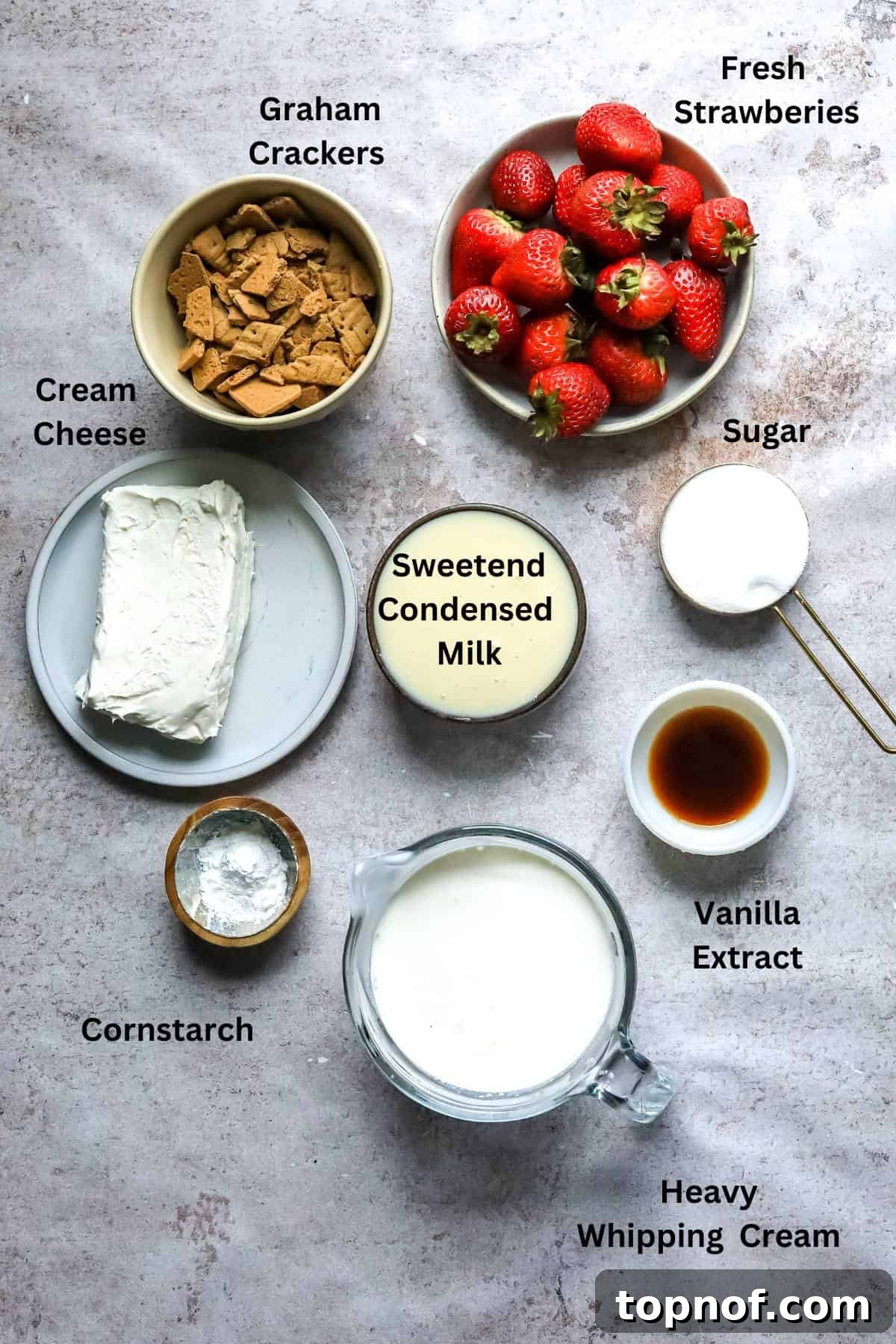 Homemade No-Churn Strawberry Cheesecake Indulgence 3 An overhead image of the ingredients for strawberry cheesecake ice cream laid out on a surface.