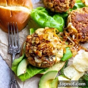 Up close photo of canned salmon burger with onions on top. A silver fork to the side.