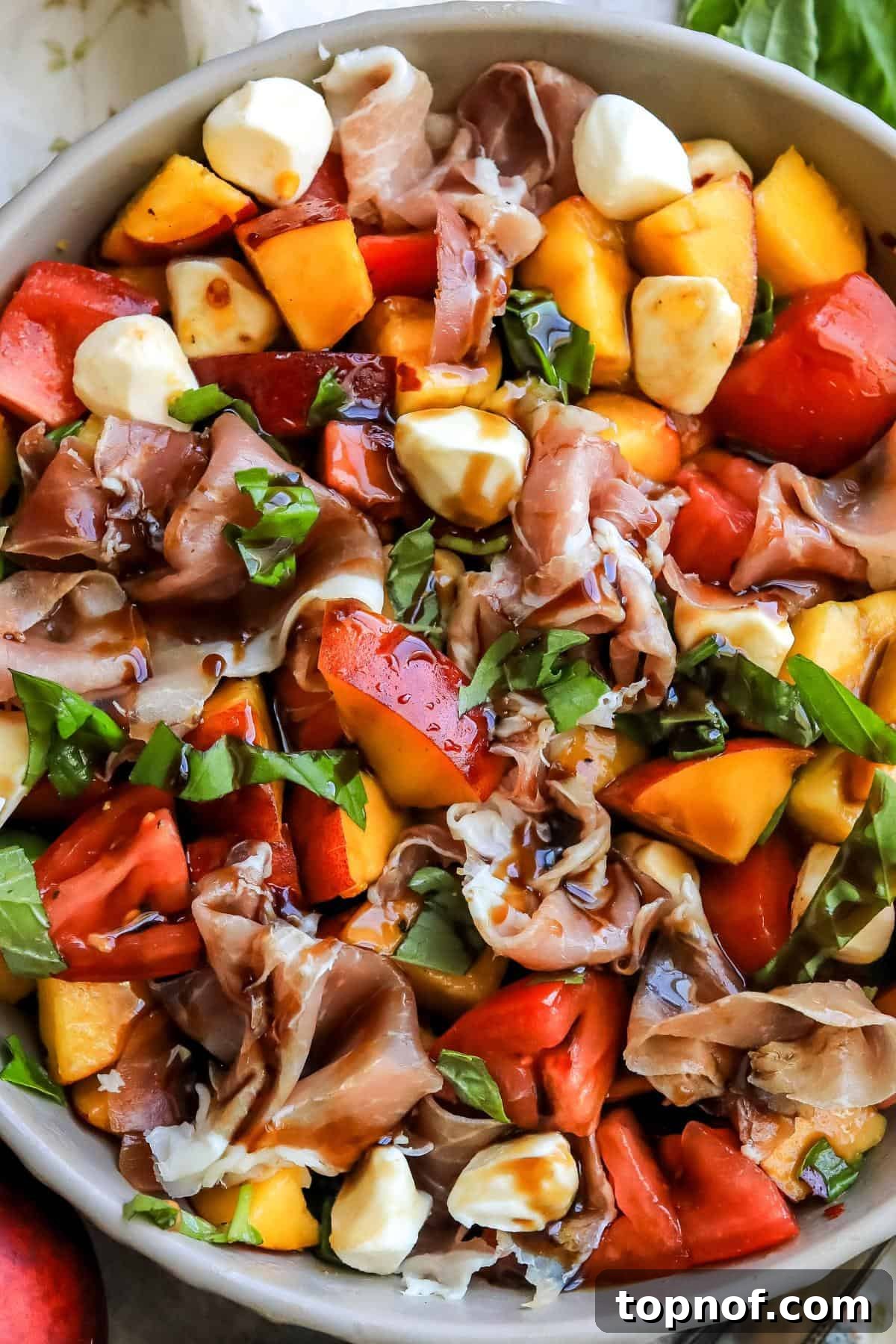 Up close photo of peach caprese salad with balsamic drizzled over the top, showcasing its appetizing appeal.