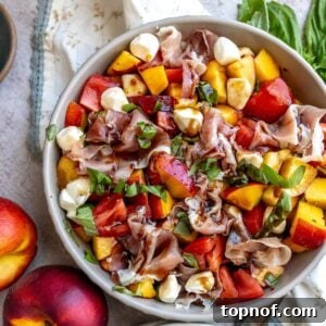 Grey bowl with peach and tomato in it, two plates on the side.