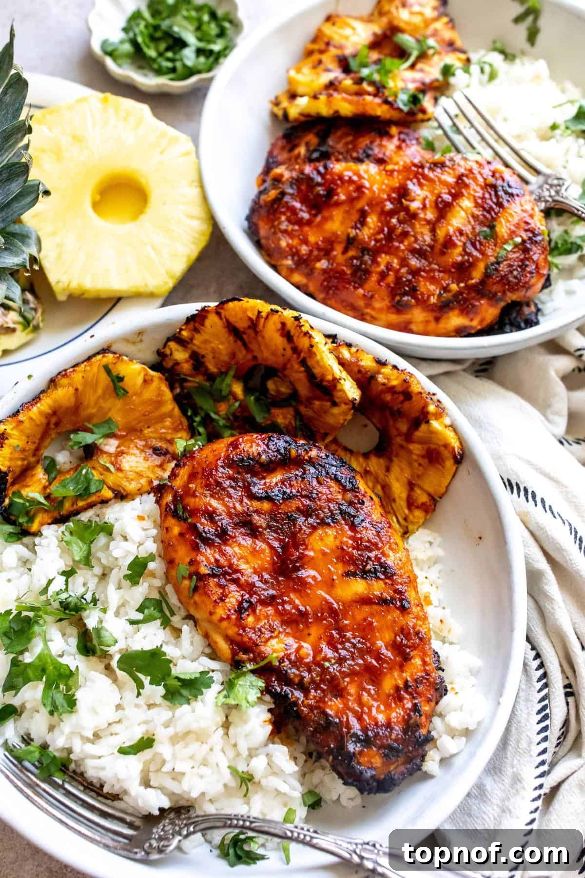 Sweet and Tangy Pineapple Chicken Adobo 2 Overhead shot of Chicken Pineapple Adobo served over coconut rice with grilled pineapple slices and fresh cilantro.