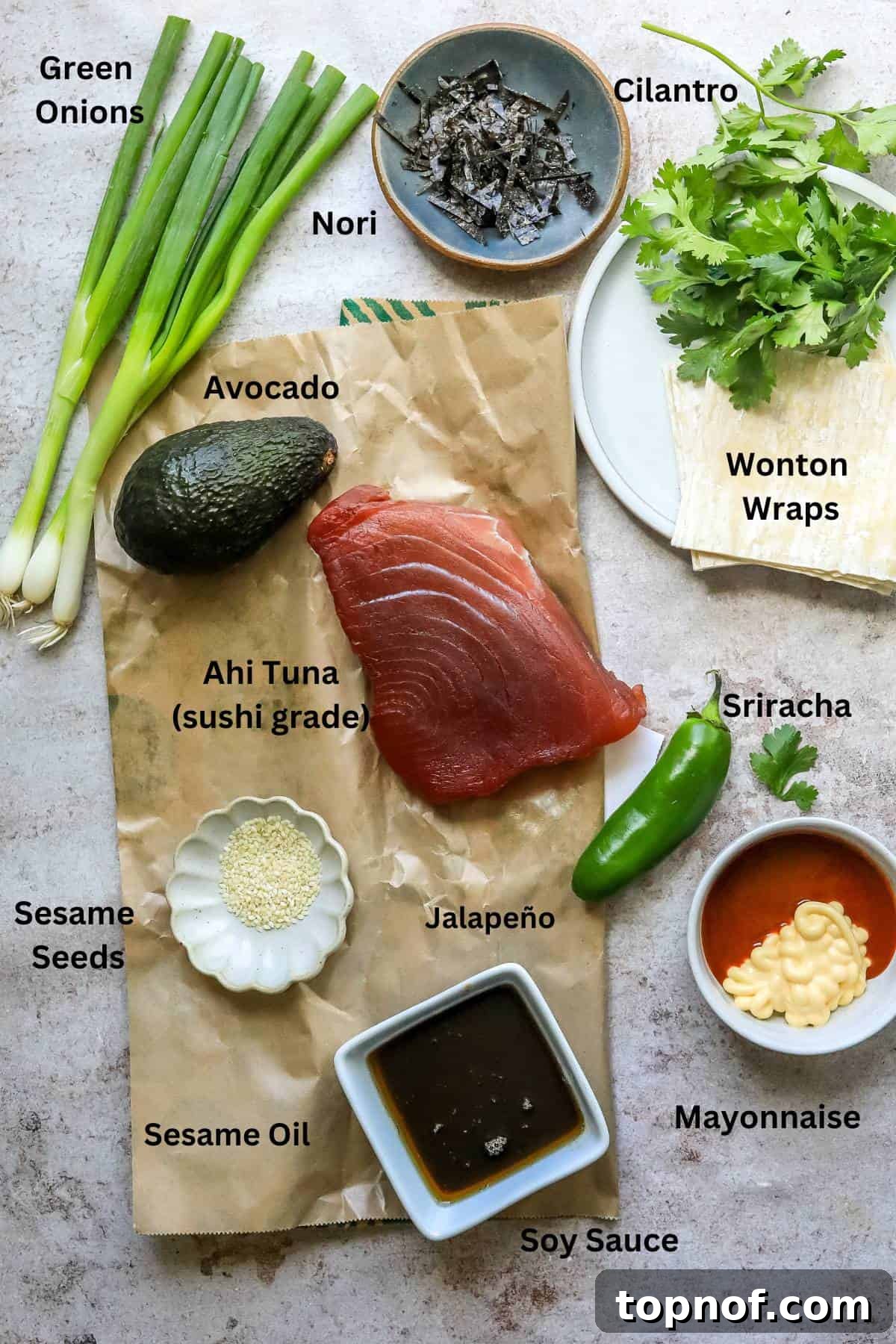 Various ingredients for Poke nachos laid out in small bowls on a kitchen counter.