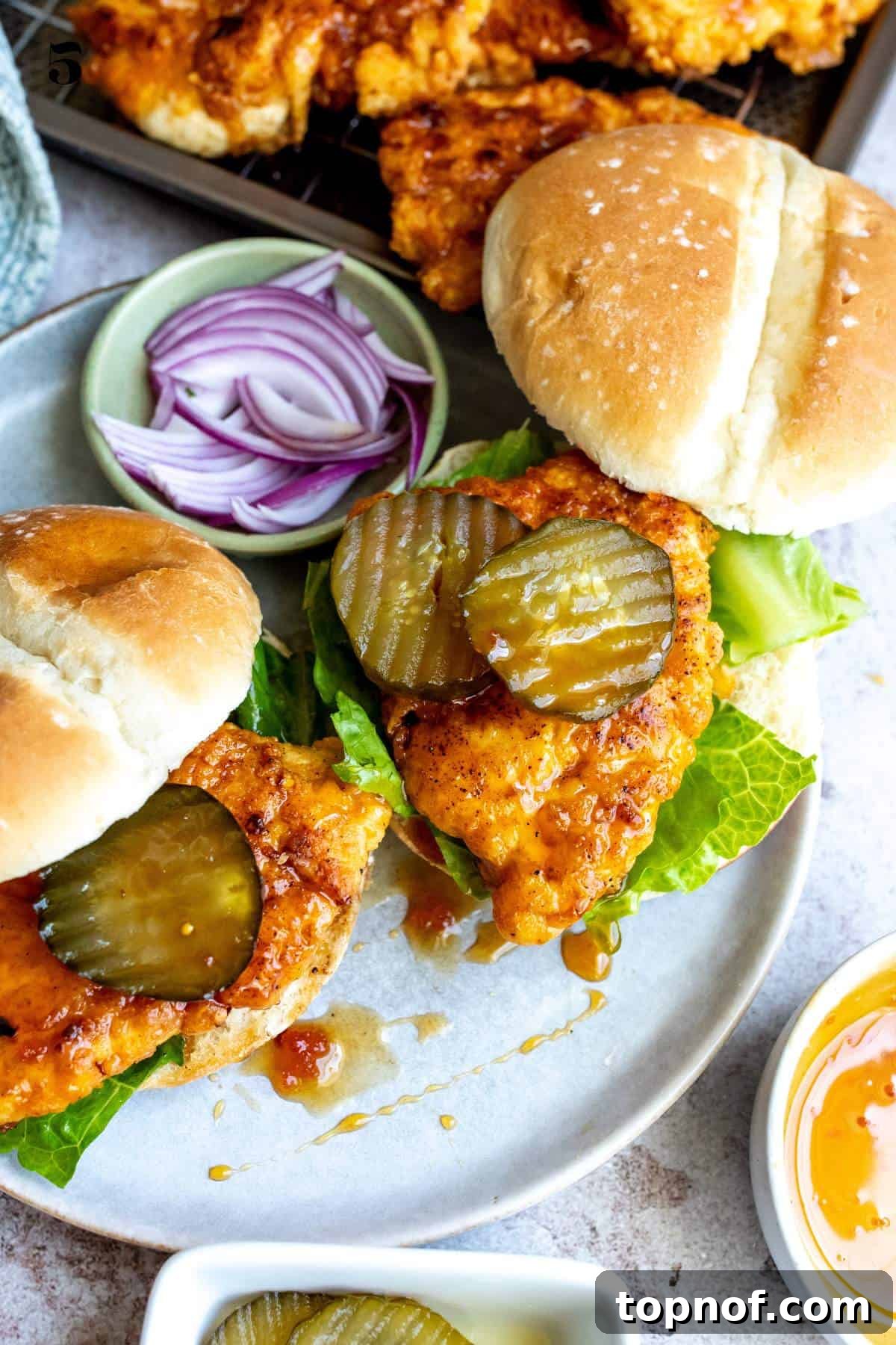 The Honey Blaze Chicken Sandwich 2 A close-up shot of a golden-brown crispy hot honey chicken sandwich, highlighting the texture of the fried chicken and the glistening honey glaze.