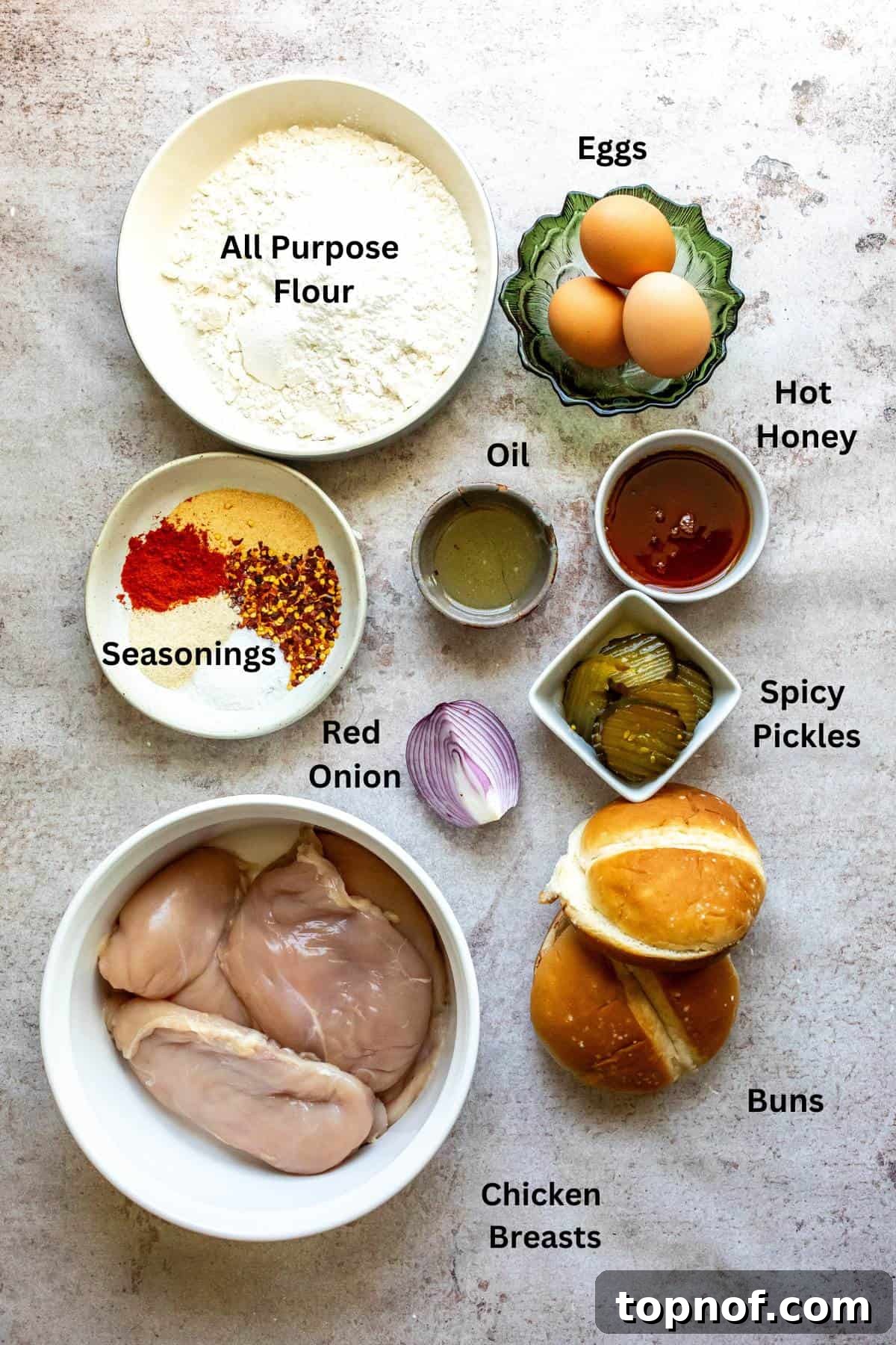 The Honey Blaze Chicken Sandwich 3 Fresh ingredients laid out for hot honey chicken sandwiches, including chicken breasts, eggs, flour, and spices, ready for preparation.