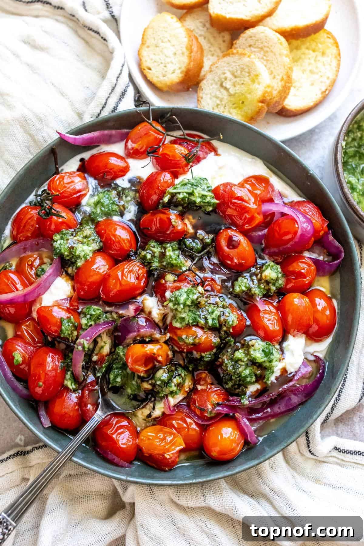Burrata Pesto Perfection 2 Pesto Burrata in a green bowl with bread to the side, ready to be served.